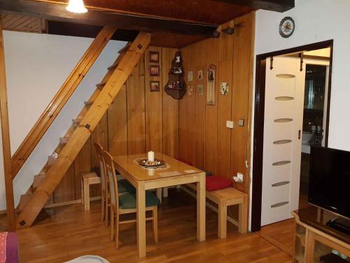 ein Esszimmer mit einem Tisch und einer Treppe in der Unterkunft Holiday home Marianska/Erzgebirge 1668 in Zálesí