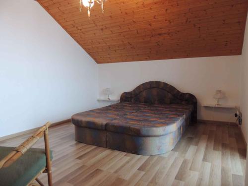 a large bed in a room with a wooden ceiling at Holiday home Sedlonov/Adlergebirge 949 in Sedloňov