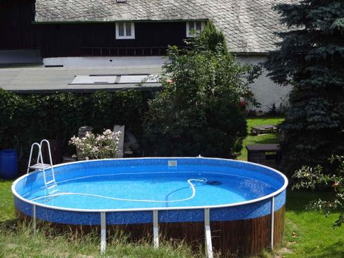 une grande piscine bleue dans une cour avec une maison dans l'établissement Rekreacni dum s velkou zahradu a venkovnim bazen, à Frýdlant