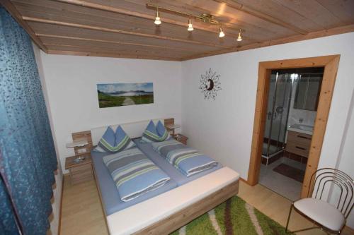 una camera da letto con letto e cuscini blu di Apartment in Stummerberg/Zillertal 824 ad Ahrnbach