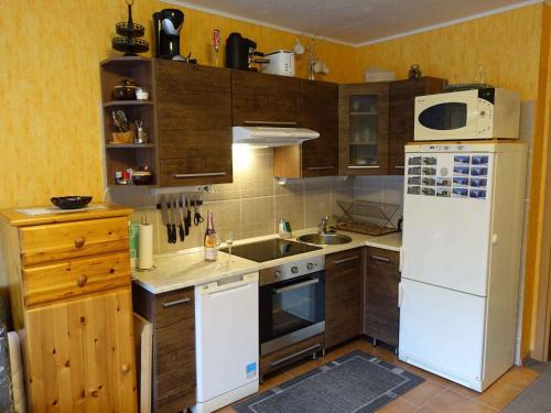 a kitchen with a white refrigerator and wooden cabinets at Studio in Bad Aussee/Steiermark 428 in Helmbichl
