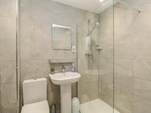 a bathroom with a shower and a toilet and a sink at Rockpools in Weymouth