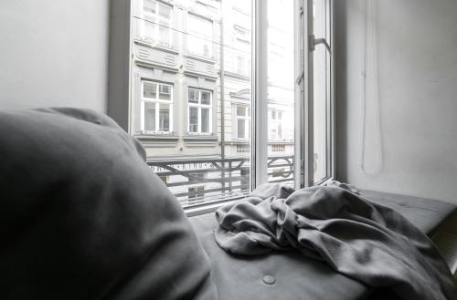 um cobertor deitado num sofá em frente a uma janela em Main square apartment good Stay in the city center em Lviv