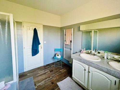 La salle de bains est pourvue d'un lavabo, d'un miroir et d'une porte. dans l'établissement Villa avec piscine Andernos les Bains, à Andernos-les-Bains