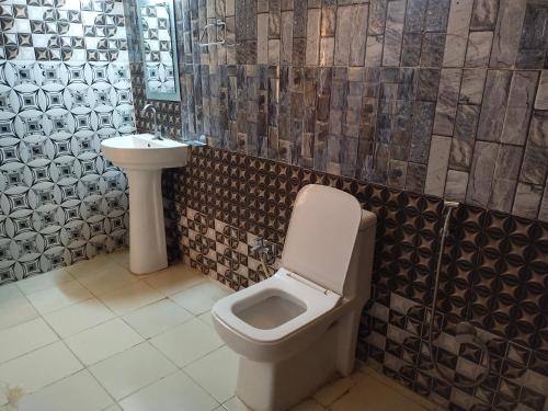 a bathroom with a toilet and a sink at Aroma Desert Safari Camp in Sām