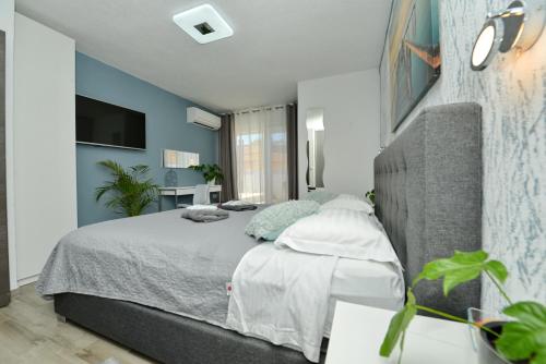 a bedroom with a large bed with blue walls at Pop holiday house Zadar in Zadar