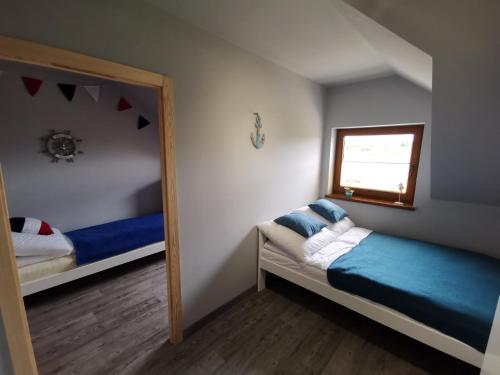 a small bedroom with two beds and a mirror at Domki LUNA in Sarbinowo
