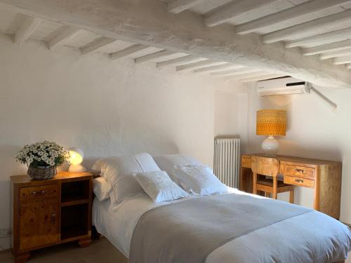 ein Schlafzimmer mit einem Bett und einem Tisch mit einer Lampe in der Unterkunft Villa Caprera in Siena