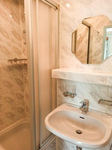 a bathroom with a sink and a shower at Landhotel Waldschänke in Berlin