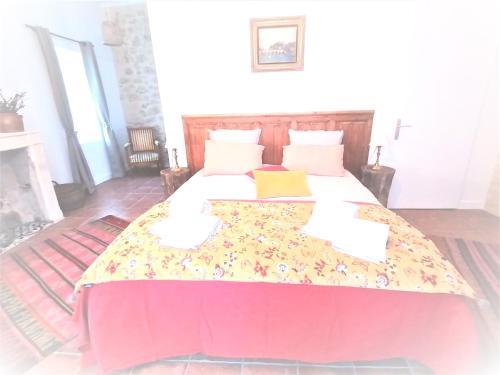 a bedroom with a large bed with a colorful blanket at Domaine de Gaïa, Piscine, Pétanque, Ping-pong, proche Saint Emilion in Guillac
