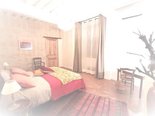 a bedroom with a bed and a table and a window at Domaine de Gaïa, Piscine, Pétanque, Ping-pong, proche Saint Emilion in Guillac