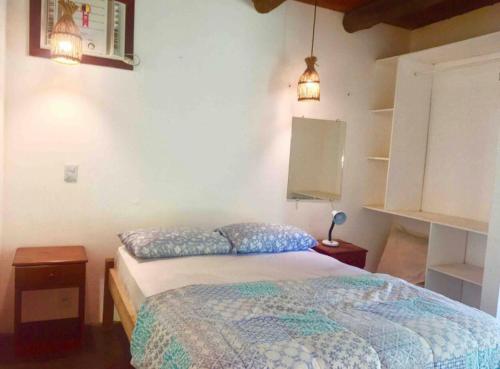 a bedroom with a bed and two pillows on it at Casa Bromélia Green in Itacaré