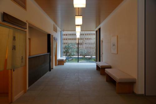 a hallway in a building with benches and a window at yubune in Onomichi