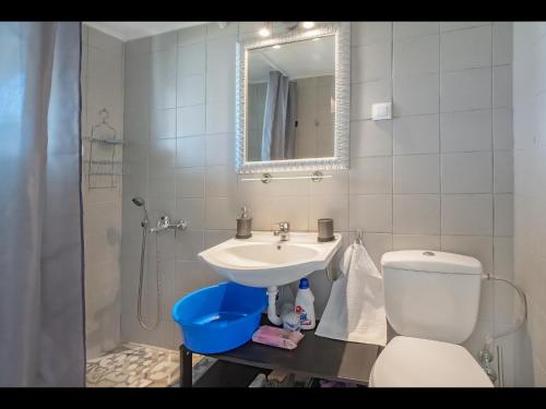 a bathroom with a sink and a toilet and a mirror at Sea La Vie in Skala Rachoniou