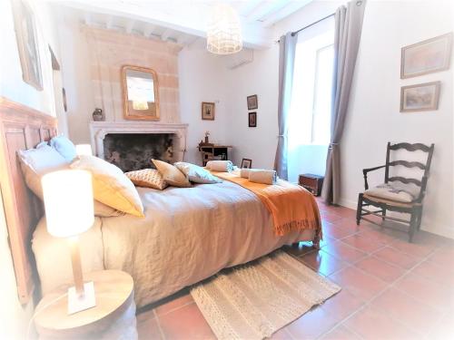 a bedroom with a large bed and a chair at Domaine de Gaïa, Piscine, Pétanque, Ping-pong, proche Saint Emilion in Guillac