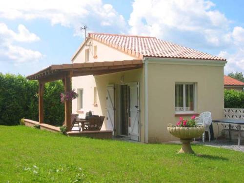 Cette petite maison blanche dispose d'une terrasse couverte et d'une table. dans l'établissement colombo, à Lacrouzette