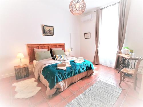 a bedroom with a bed and a table and a window at Domaine de Gaïa, Piscine, Pétanque, Ping-pong, proche Saint Emilion in Guillac