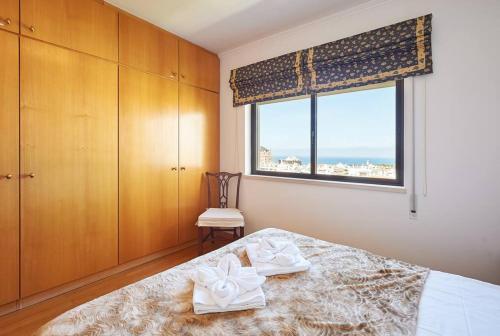 a bedroom with a bed and a window with the ocean at Lighthouse View in Cascais in Cascais