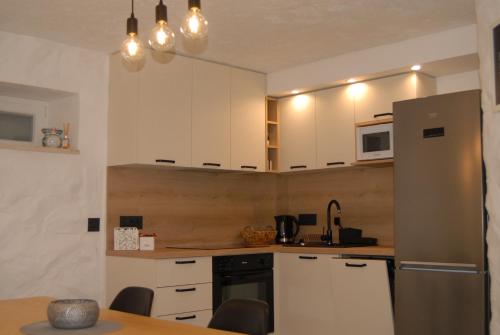a kitchen with white cabinets and a refrigerator at Guest house Otto in Punat