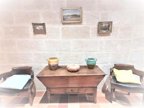 a table and two chairs with bowls on it at Domaine de Gaïa, Piscine, Pétanque, Ping-pong, proche Saint Emilion in Guillac