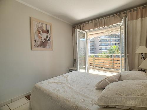 um quarto com uma cama e uma grande janela em ZEN MARINA em Mandelieu-la-Napoule