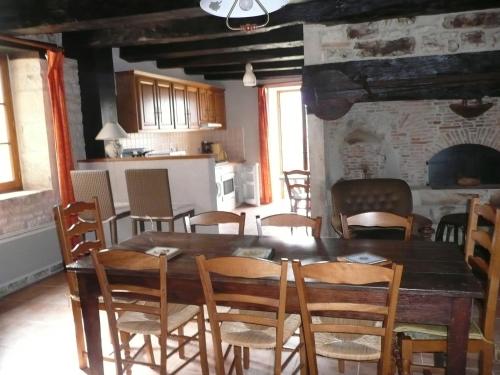 une cuisine et une salle à manger avec une table et des chaises en bois dans l'établissement gite la chapelle, à Nailhac