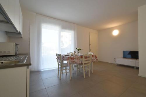 a kitchen and dining room with a table and chairs at Residence Al Molo - Agenzia Cocal in Caorle