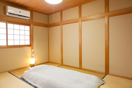 KoizumiにあるHAT Koizumi, near from JR Koizumi station 大和小泉駅徒歩2分の貸切一軒家のベッド1台、照明、窓が備わる客室です。