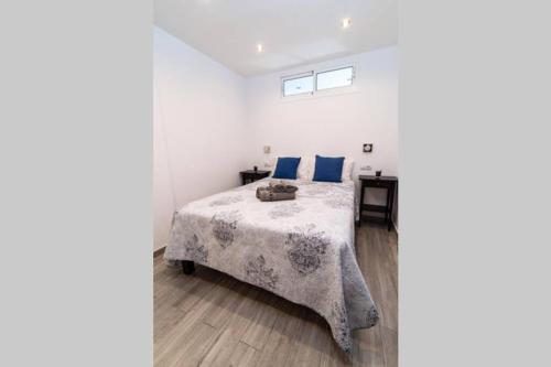 a white bedroom with a bed with blue pillows at Los Molinos apartment Ocean View in Playa del Ingles