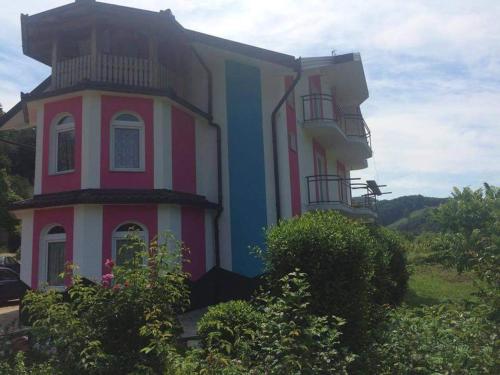 Dieses rosa und blaue Gebäude verfügt über einen Balkon. in der Unterkunft Vila Anđelija in Velika Kladuša