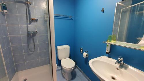 ein blaues Badezimmer mit WC und Waschbecken in der Unterkunft Hotel Amethist in Ramsel
