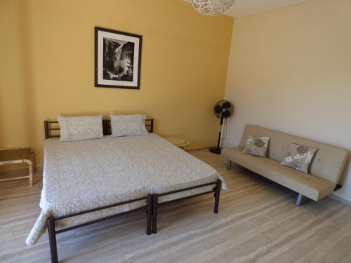 a bedroom with a bed and a couch at GEORGES IPSOS APARTMENTS in Ipsos