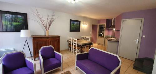 a living room with two purple chairs and a kitchen at Gite Pago in Villefranche-de-Rouergue