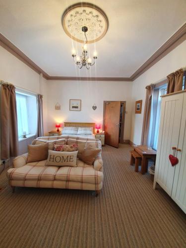 a bedroom with a bed and a couch at Caulfields Hotel in Burry Port