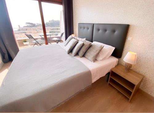 Un dormitorio con una cama grande con una ventana grande. en Apartamento Tossa de Mar, en Tossa de Mar