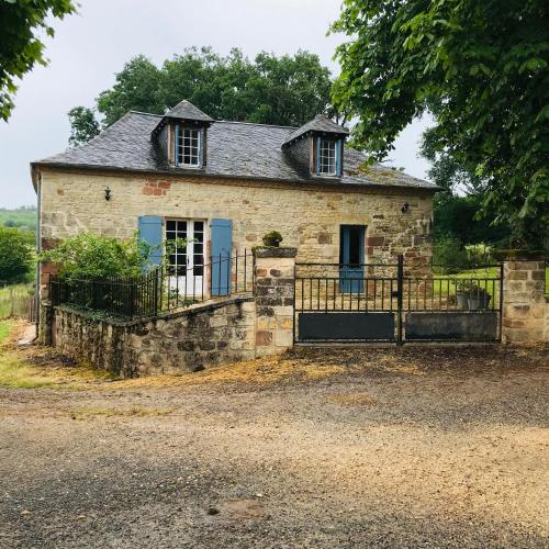 une ancienne maison en pierre avec un portail et une clôture dans l'établissement gite Le Verdier, à Nailhac