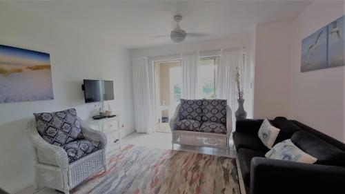 uma sala de estar com um sofá e duas cadeiras em 20 Key Largo em Amanzimtoti