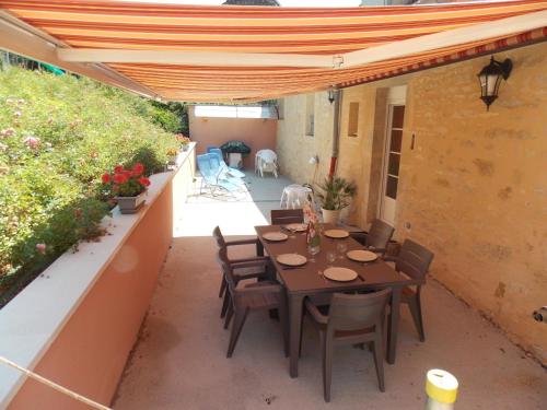 a patio with a table and chairs under a pergola at GITE DES ROCHES in La Roche-Vanneau