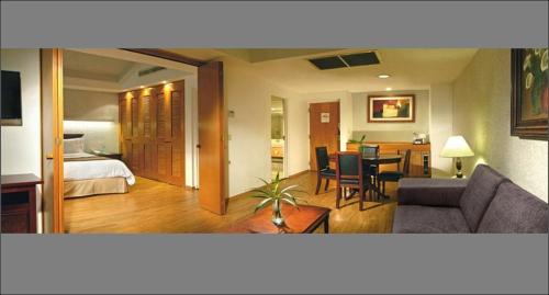 a living room with a couch and a dining room at Hotel Horizon & Convention Center in Morelia