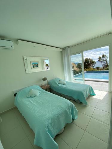 two beds in a room with a view of the ocean at Le Loft in Ajaccio