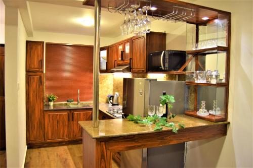 cocina con armarios de madera y encimera en Lake Infinity Luxury Condos en Nuwara Eliya