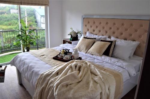a bedroom with a large bed with a large window at Lake Infinity Luxury Condos in Nuwara Eliya