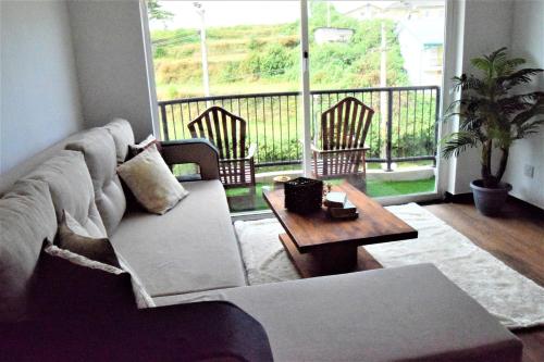 a living room with a couch and a table at Lake Infinity Luxury Condos in Nuwara Eliya