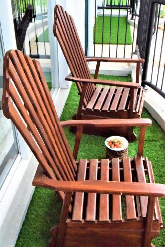 two wooden rocking chairs sitting on a porch at Lake Infinity Luxury Condos in Nuwara Eliya