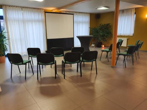 a conference room with chairs and a projection screen at Hotel Amethist in Ramsel