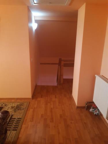 an empty room with a table and a wooden floor at Cabana Gabriela in Gîrda de Sus