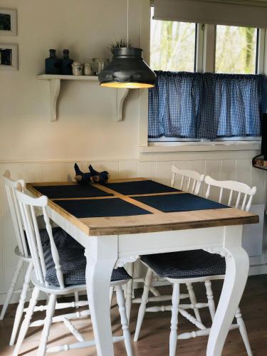 a kitchen with a white table and chairs at Pension Lærkelill in Skovlund