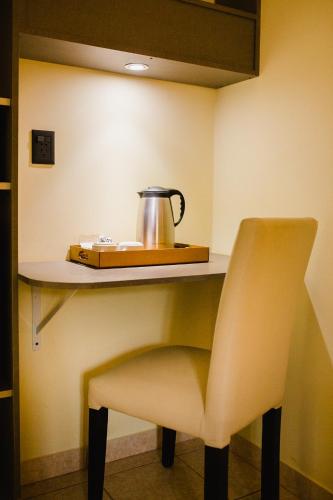 a tea kettle on a shelf next to a chair at Hotel Che Roga in Puerto Eldorado