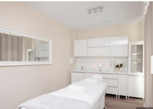 a white room with a bed and a mirror at Bel Mare 405 in Międzyzdroje