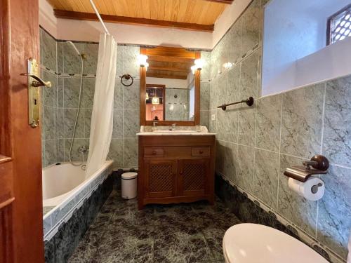 La salle de bains est pourvue d'un lavabo, d'une baignoire et de toilettes. dans l'établissement Casa El Patio, à Hermigua